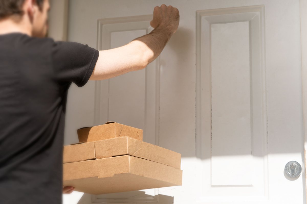 Courex uniformed courier greeting recipient with parcel signature pad